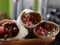 three burritos filled with meat and vegetables on a plate