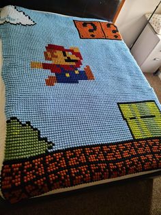 a bed with a blanket made to look like a video game character on the cover