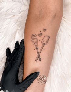 a woman with a tattoo on her arm holding a black glove next to a white fur rug