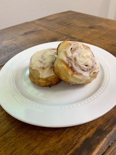 two cinnamon rolls sitting on top of a white plate