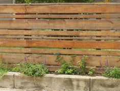 a wooden bench sitting in the middle of a garden with flowers growing on it's sides