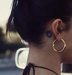 a woman wearing large gold hoop earrings on her neck