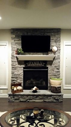 a living room filled with furniture and a flat screen tv mounted above a fire place