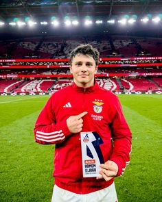 a man standing on top of a soccer field holding a plaque in front of him