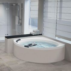 a large white bath tub sitting inside of a bathroom next to a walk in shower