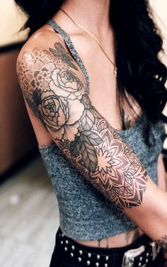 a woman with long black hair and tattoos on her arm