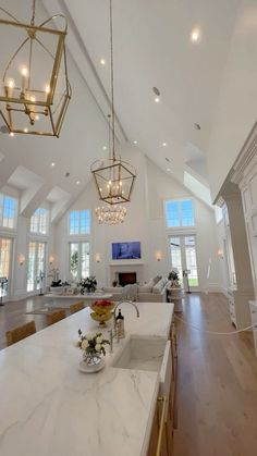 a large kitchen with an island and chandelier hanging from it's ceiling