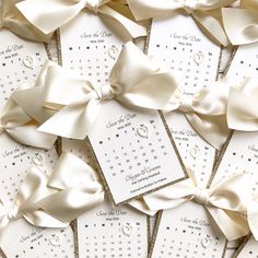 many white cards with bows on them are laid out in the shape of calendars