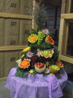 a table topped with lots of different types of fruit on top of a purple cloth