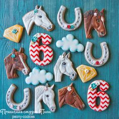 decorated cookies are arranged in the shape of horses and horseshoes on a blue background