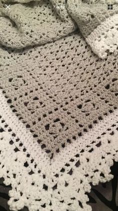 a white crocheted blanket on top of a bed