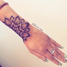 a woman's hand with a flower tattoo on the left wrist and right arm