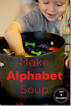 a young boy is playing with an alphabet soup in a black bowl that says make alphabet soup