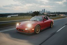 a red sports car driving down the highway