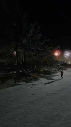 two people are walking in the snow at night with fireworks coming out of their heads