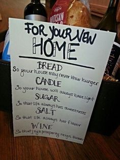 a sign that says for your own home bread and wine are on the table next to a bottle of wine