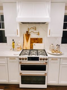 a white stove top oven sitting inside of a kitchen next to a counter and cabinets