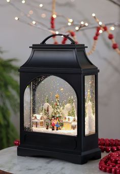 a christmas scene in a black lantern on a table