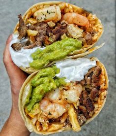 two tacos with meat, shrimp and guacamole on them