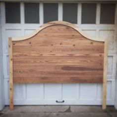 a wooden headboard in front of a garage door