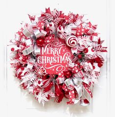 a christmas wreath with red and white bows, candy canes and merry lettering on it