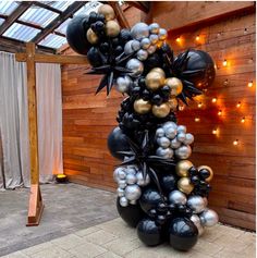 a bunch of balloons that are in the shape of a tree with lights on it