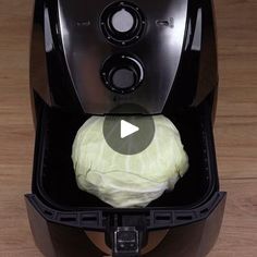 a video demonstrating how to use an air fryer with cabbage in it on a wooden table