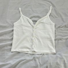 Brandy Melville Tank Top One Size Condition: Nwot Color: White Details : - Button-Down - Waist Length - Sweetheart Neckline - Versatile Piece, Can Be Styled Various Ways For Various Seasons Extra: - I Ship Between 1-2 Days Casual Cotton Tank Top With Buttons, Casual White Buttoned Tank Top, White Cotton Tank Top With Button Closure, White Cotton Tank Top With Buttons, White Cotton Buttoned Tank Top, White Button-up Tank Top For Spring, V-neck Cotton Tank Top With Buttons, Cotton V-neck Tank Top With Buttons, White Buttoned Top For Everyday Wear