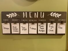 a menu hanging on the wall with notes pinned to it's sides and magnets