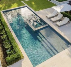 an aerial view of a swimming pool with lounge chairs