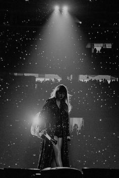 a black and white photo of a woman on stage