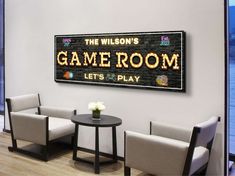 a game room with chairs and tables in front of a large sign that says the wilson's game room lets play