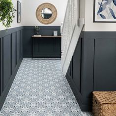 an entryway with blue and white tiles on the floor, black painted walls and stairs