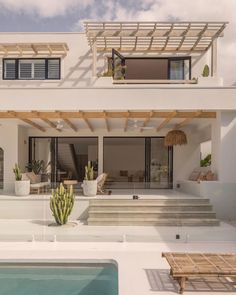 a house with a pool in front of it and some plants on the outside wall