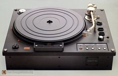 an old record player sitting on top of a black box with buttons and knobs