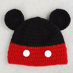 a crocheted mickey mouse hat with ears on it's head, laying on a white surface