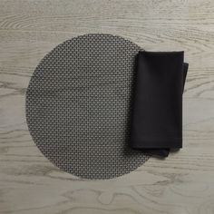 a placemat and black napkins on a wooden table