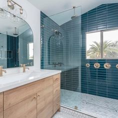 a bathroom with blue tile and wooden cabinetry is pictured in this image from the front view