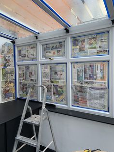 a ladder leaning up against a window covered in newspapers