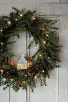 a christmas wreath with pine cones and lights