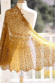 a crocheted shawl on a mannequin in front of a window