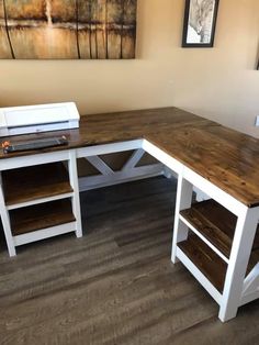 a desk with two shelves and a printer sitting on top of it in front of a painting