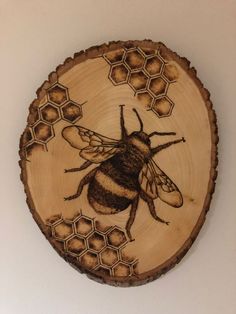 a wooden plate with a bee painted on it