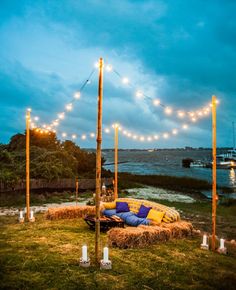 a couch sitting on top of a lush green field next to a body of water