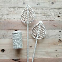 two spools of twine next to each other on top of a wooden surface