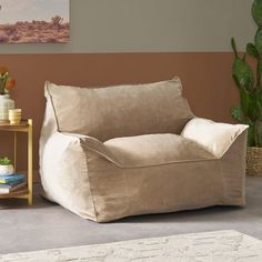 a living room with a chair and potted plant on the side table next to it