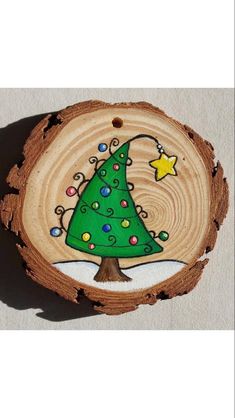 a wooden slice with a christmas tree painted on it