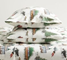 three pillows stacked on top of each other in front of a white background with christmas trees