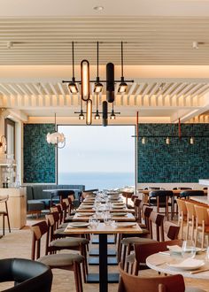 an empty restaurant with tables and chairs overlooking the ocean