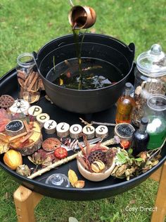 an outdoor table with various items on it and a bowl full of water in the middle